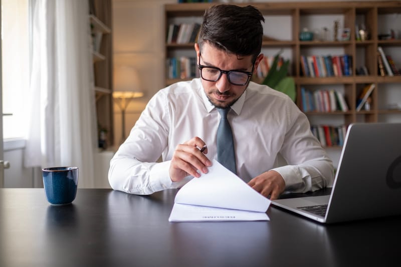 Autor revisando las páginas de un manuscrito